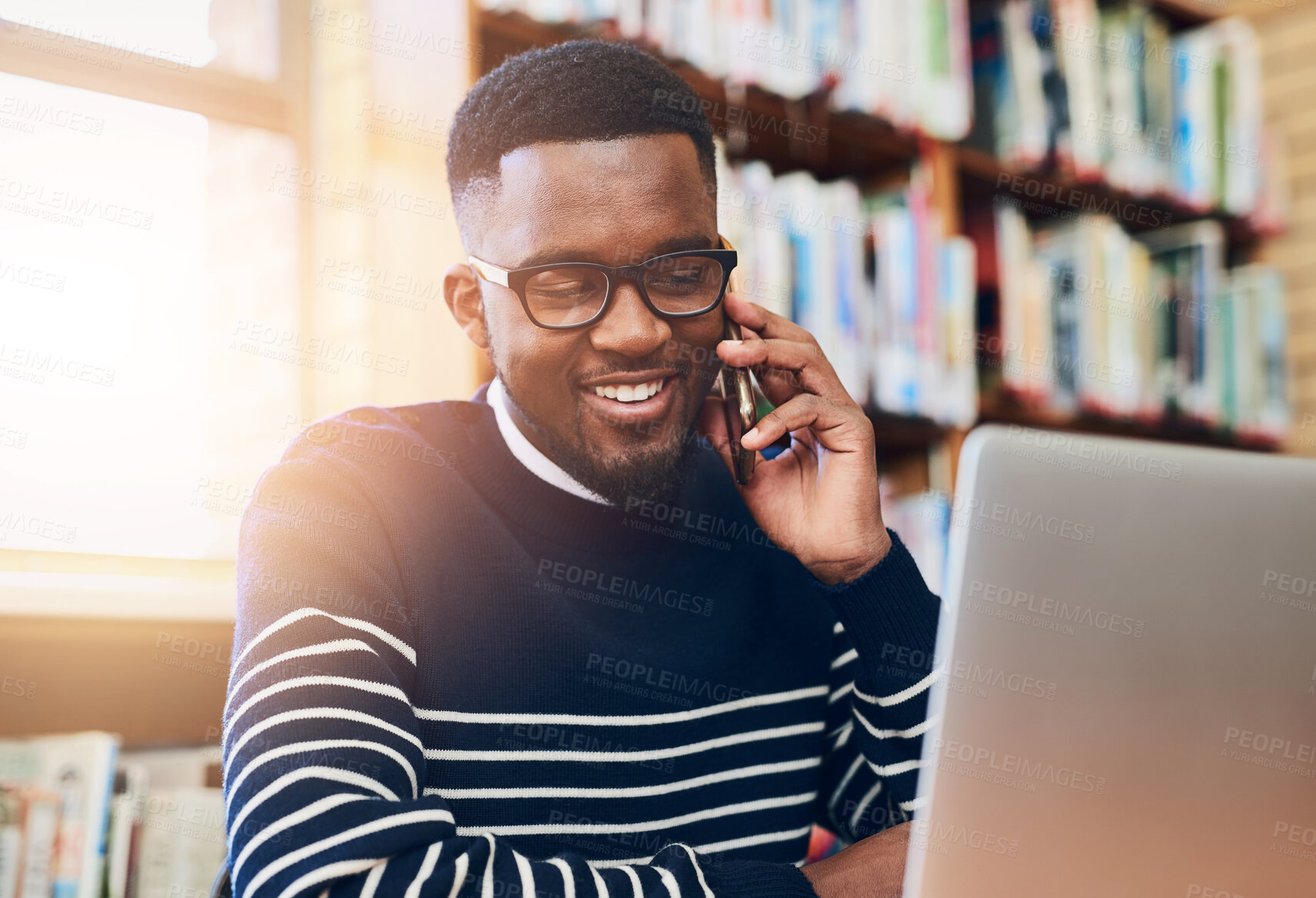 Buy stock photo Black man, smile and laptop with phone call in library for university website, communication and planning. Happy, student and technology with discussion for education, online results or information