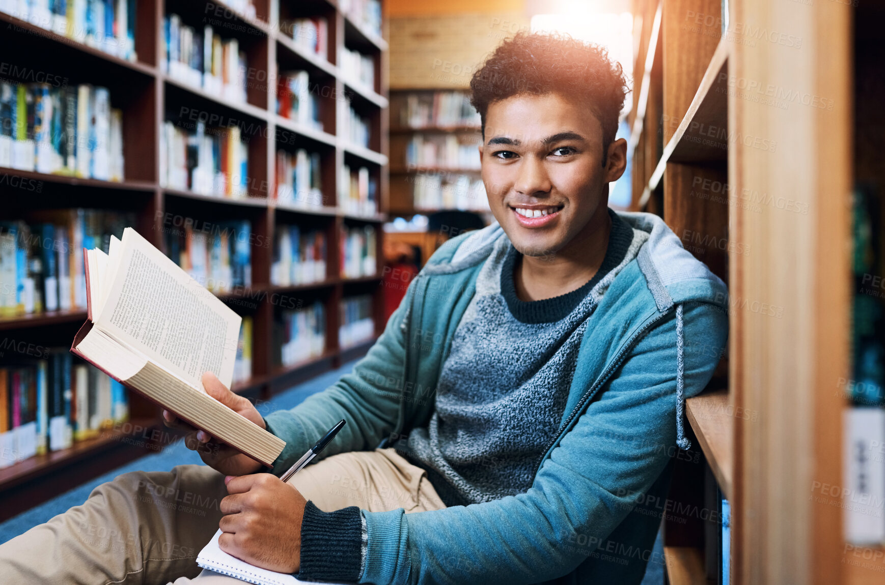 Buy stock photo Student, man and portrait with writing in library for studying, scholarship and reading a book for exam information. Education, person or happy with notebook for research notes and knowledge on floor