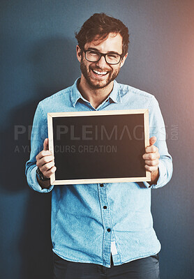 Buy stock photo Smile, portrait and man with chalkboard for mockup space with marketing, promotion or advertising. Happy, glasses and male teacher from Canada with sign for education isolated by studio background.