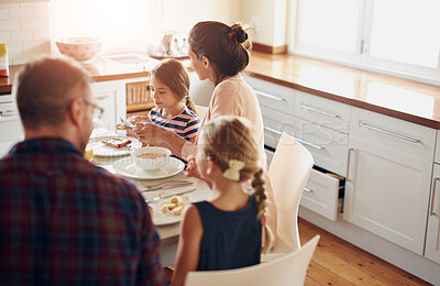 Buy stock photo Family, food and parents with children at table for breakfast, eating and bonding together in kitchen. Morning, happy woman and man with young kids for healthy meal, nutrition and hunger in home