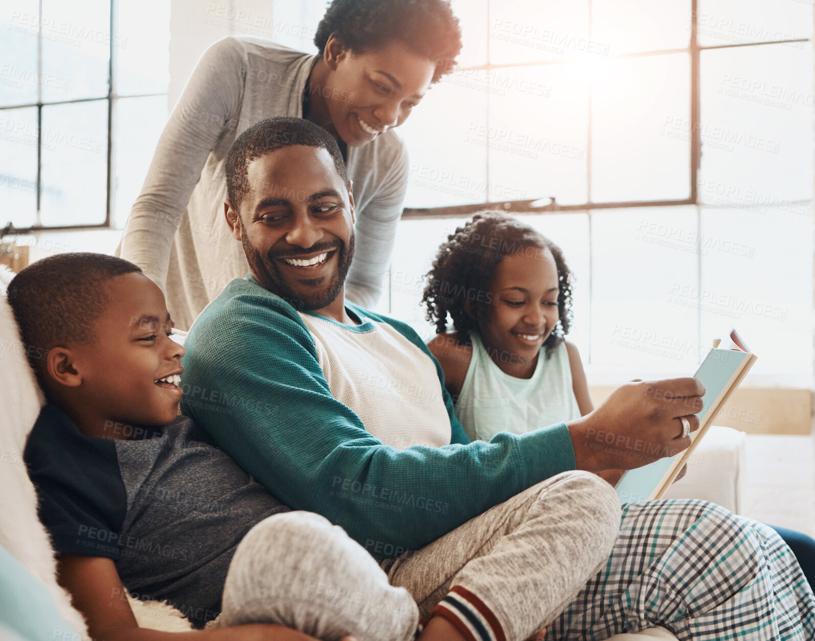 Buy stock photo Black family, book and children with reading on sofa with smile, care and learning for language in home. African parents, people and storytelling for connection, bonding and relax in pajamas on couch