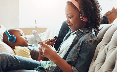 Buy stock photo Happy children, phone and relax with headphones of siblings on sofa for online streaming, music or gaming at home. Brother and sister enjoying free time or leisure on mobile smartphone in living room