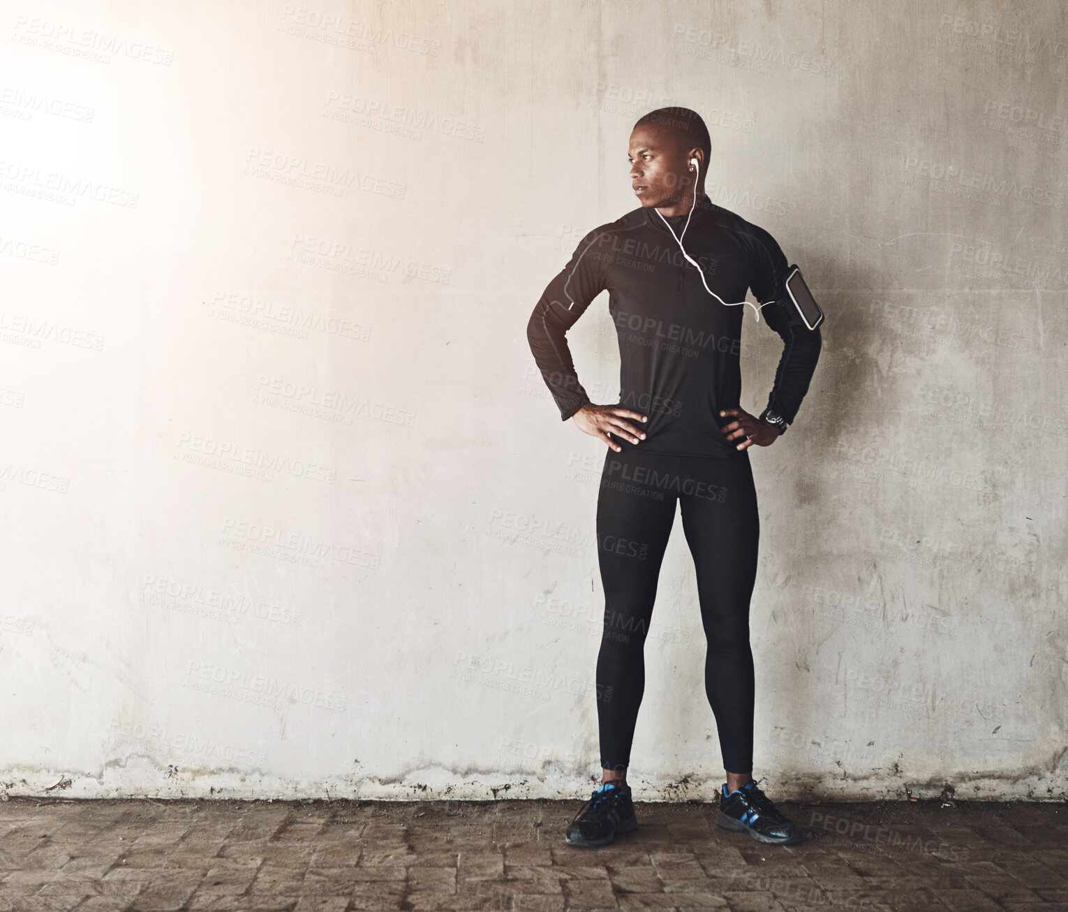 Buy stock photo Thinking, fitness and black man with earphones on wall background for wellness, routine or marathon training with mockup. Sports, space or African runner streaming music, podcast or radio for workout