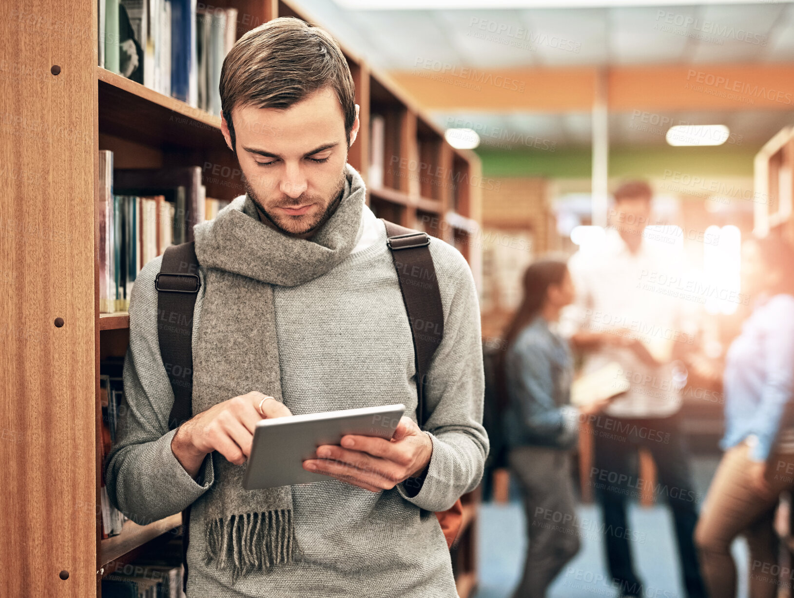 Buy stock photo Bookshelf, university and man with tablet in library for social media, network or education update. Academy, student and person with internet on tech for campus website, notification and information