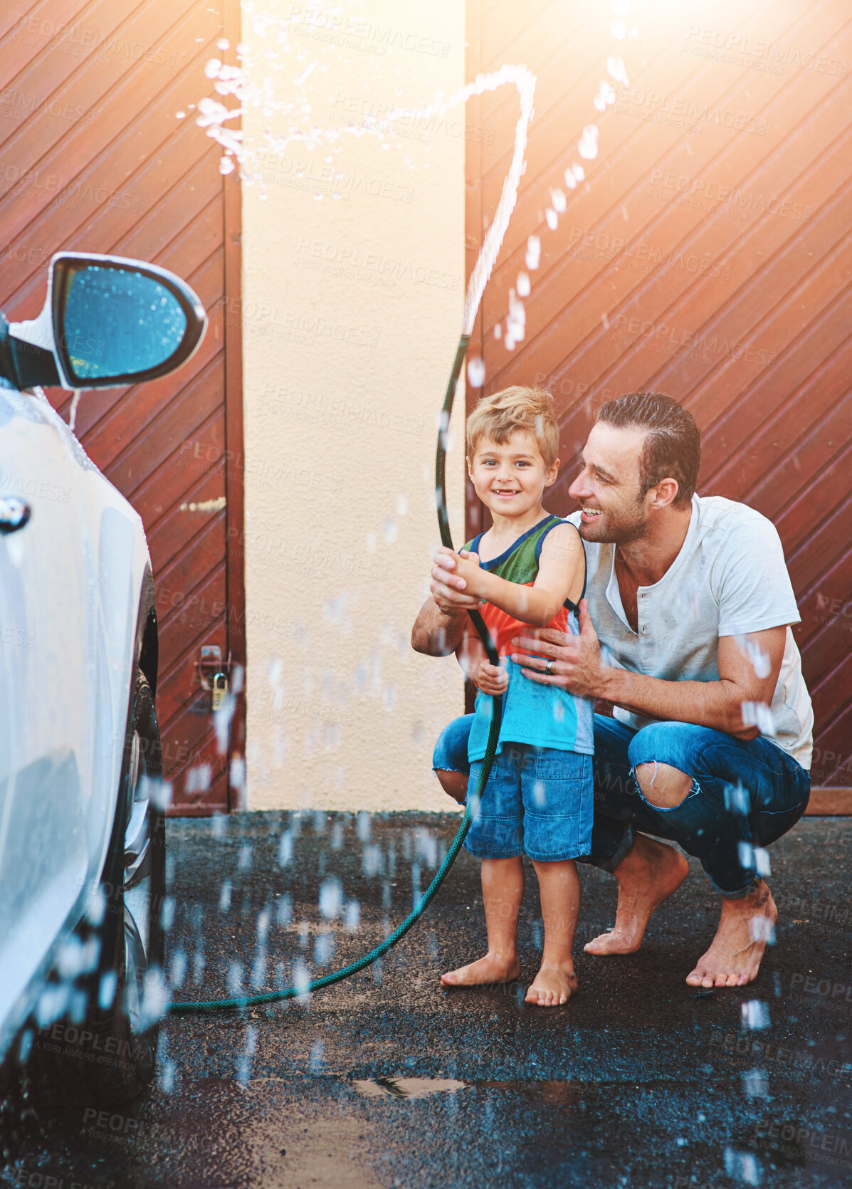 Buy stock photo Dad, boy and home with washing car for fun on day off to enjoy, smile and teaching for child development. Parent, kid and people with water hose in hot weather for bonding, support and family