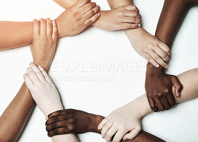 Buy stock photo Hands, diversity and circle for synergy in studio with cooperation, commitment and teamwork with wrist grip. People, together and white background with support or solidarity, trust and collaboration