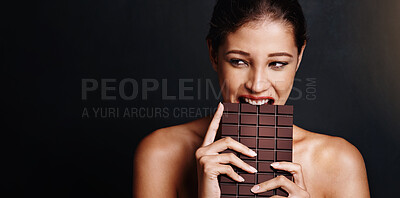 Buy stock photo Woman, eating chocolate and space in studio for mockup with thinking, choice and beauty by black background. Person, model and happy for bite or dark candy, cacao or memory with diet for antioxidants