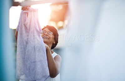 Buy stock photo Backyard, mature woman and laundry with hanging for hygiene, sanitation and cleaning in sunshine. Wet, washing and person in retirement with housework for fresh linen, maintenance and care on weekend