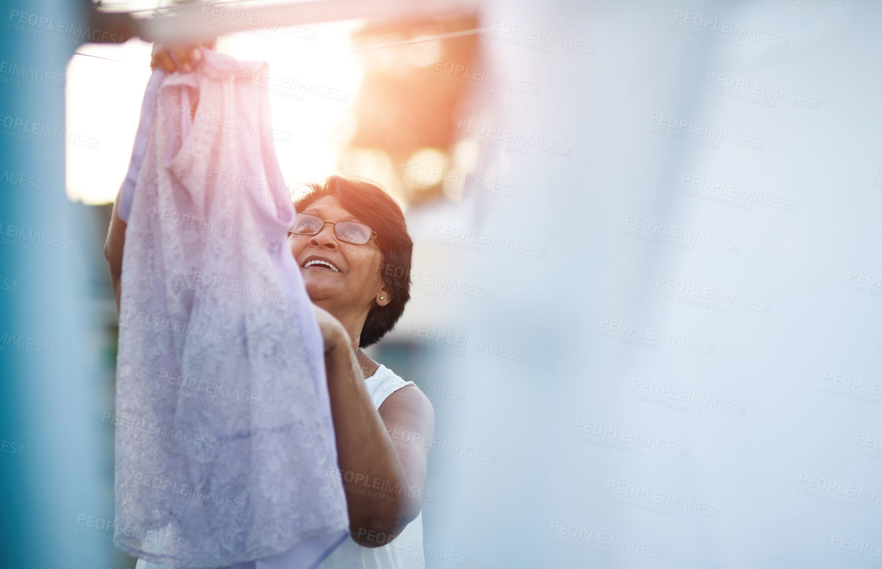 Buy stock photo Backyard, mature woman and laundry with hanging for hygiene, sanitation and cleaning in sunshine. Wet, washing and person in retirement with housework for fresh linen, maintenance and care on weekend