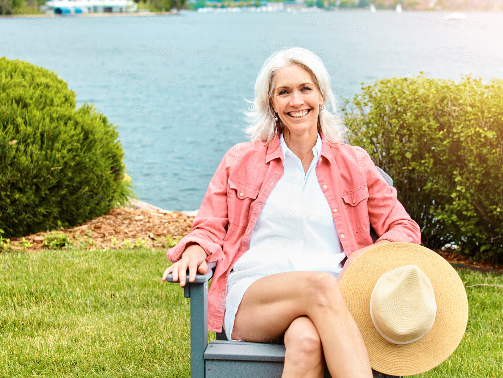 Buy stock photo Lake, portrait and smile with senior woman outdoor in garden for holiday, retirement or vacation. Chair, nature and relax with happy elderly person sitting by water in park for chilling or wellness