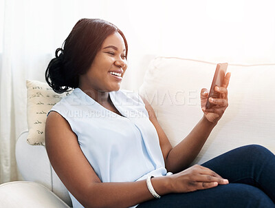 Buy stock photo Black woman, phone and relax on sofa in living room, online communication with social media or website. Female person, couch and mobile app for web conversation, scroll for happy story with internet