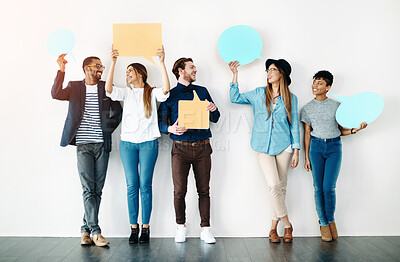 Buy stock photo Team, happy and speech bubble at wall for opinion, review or comment on social media. Diverse group, text box or sign for voice, idea or vote in studio with smile, casual fashion and white background