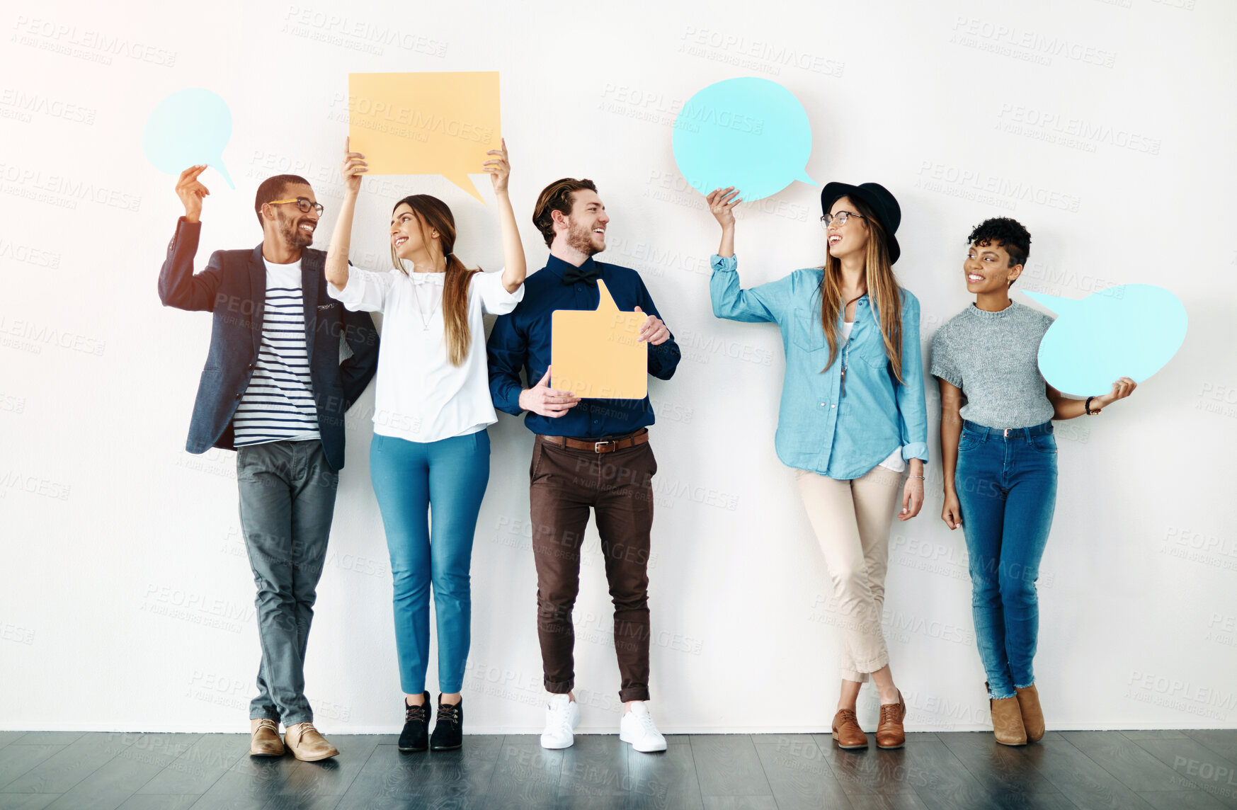 Buy stock photo Team, happy and speech bubble at wall for opinion, review or comment on social media. Diverse group, text box or sign for voice, idea or vote in studio with smile, casual fashion and white background