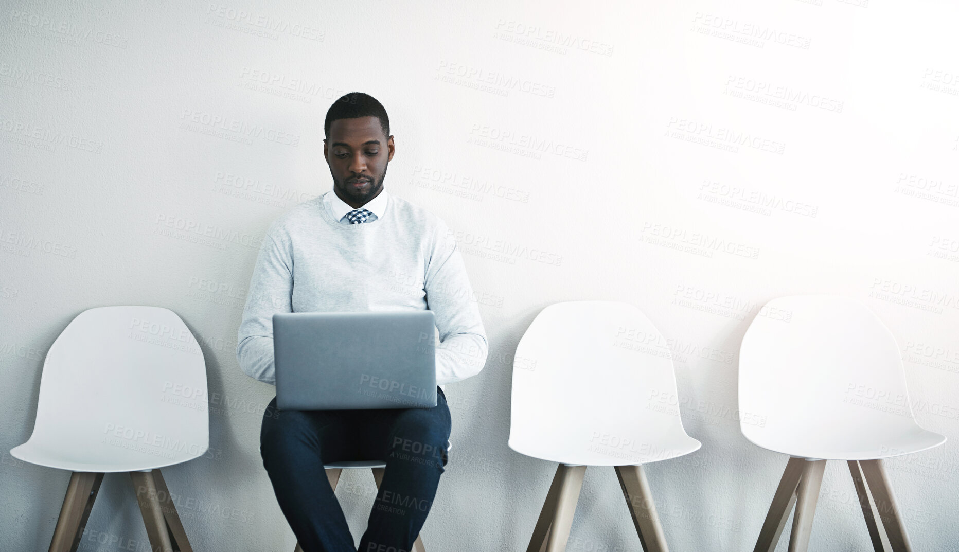 Buy stock photo Recruitment, laptop and black man in waiting room for interview, job application or hiring on chair. Human resources, typing and person with tech in office for opportunity, onboarding or employment