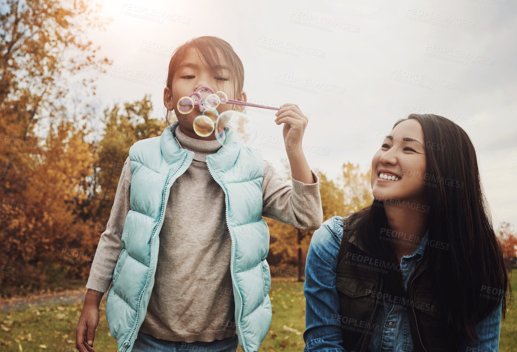 Buy stock photo Playful, mom or girl in nature with bubbles, happiness or bonding together in child growth. Fun, Asian woman or kid in park with toy, healthy relationship or connection in emotional security.