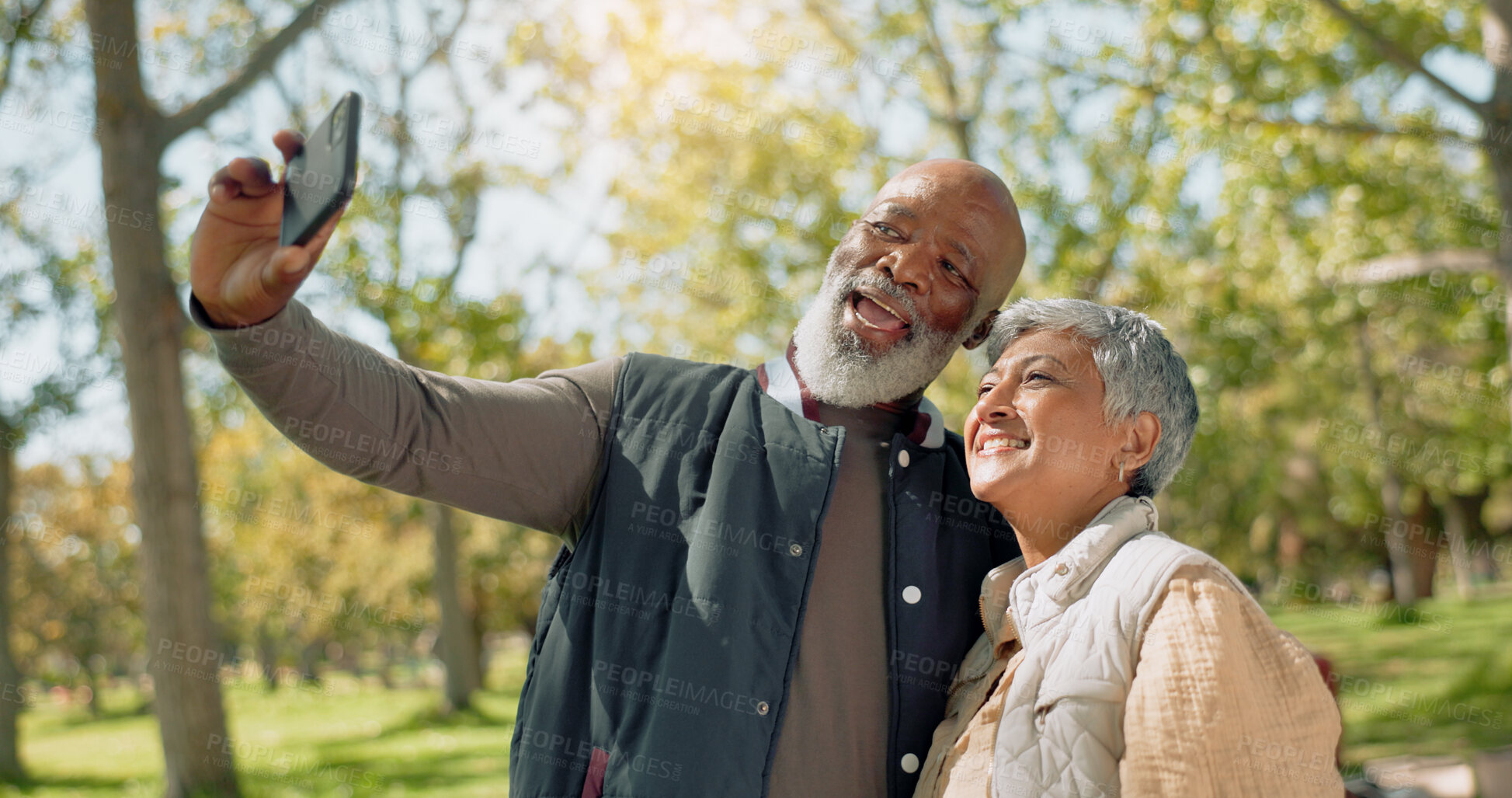 Buy stock photo Senior couple, selfie and hug in park with love, support or photography outdoor for holiday, travel or vacation. Interracial people in profile picture, vlogging or bonding with smile in New York, USA