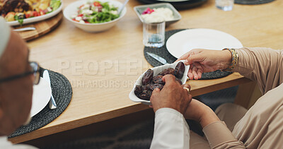 Buy stock photo Hands, lunch and eating dates for Iftar, ramadan and people breaking fast in Islamic home top view. Food, fruit and muslim family at dinner for healthy diet, nutrition and celebration of Eid al fitr