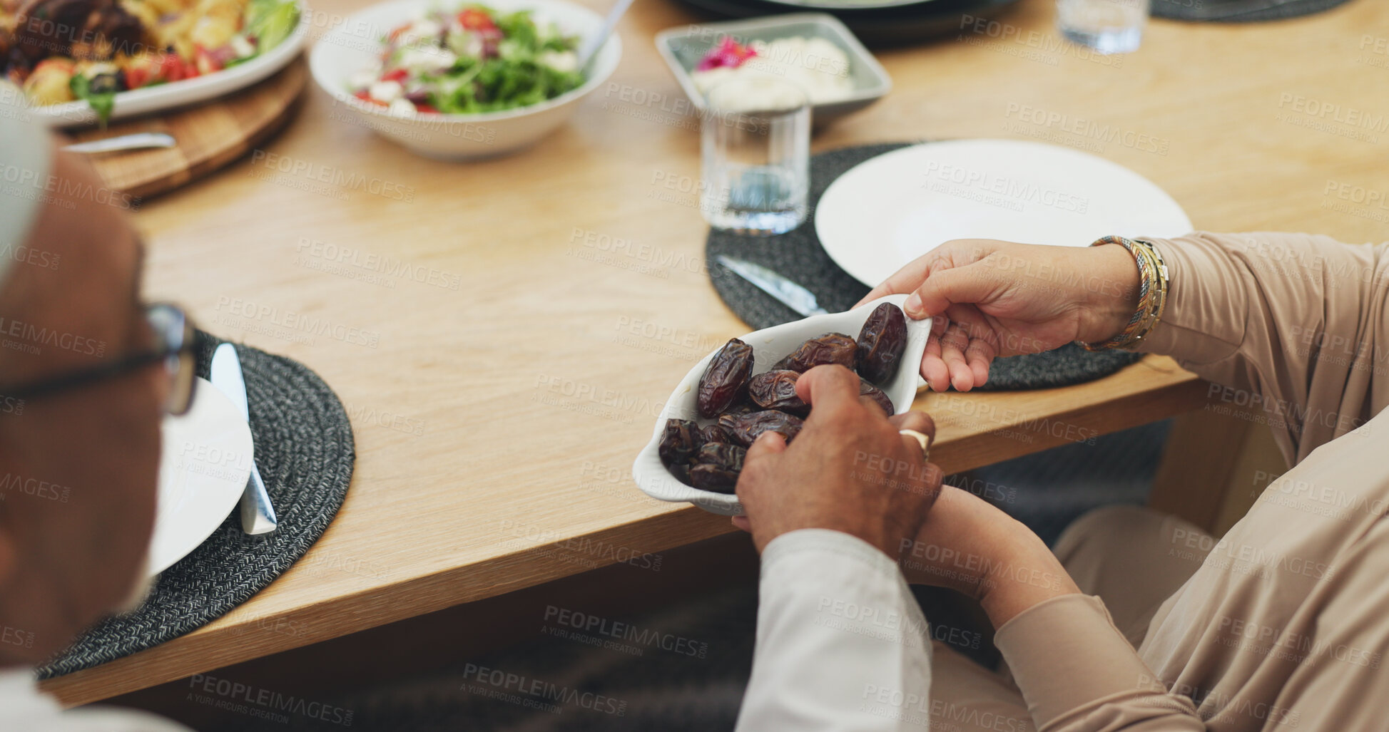 Buy stock photo Hands, lunch and eating dates for Iftar, ramadan and people breaking fast in Islamic home top view. Food, fruit and muslim family at dinner for healthy diet, nutrition and celebration of Eid al fitr