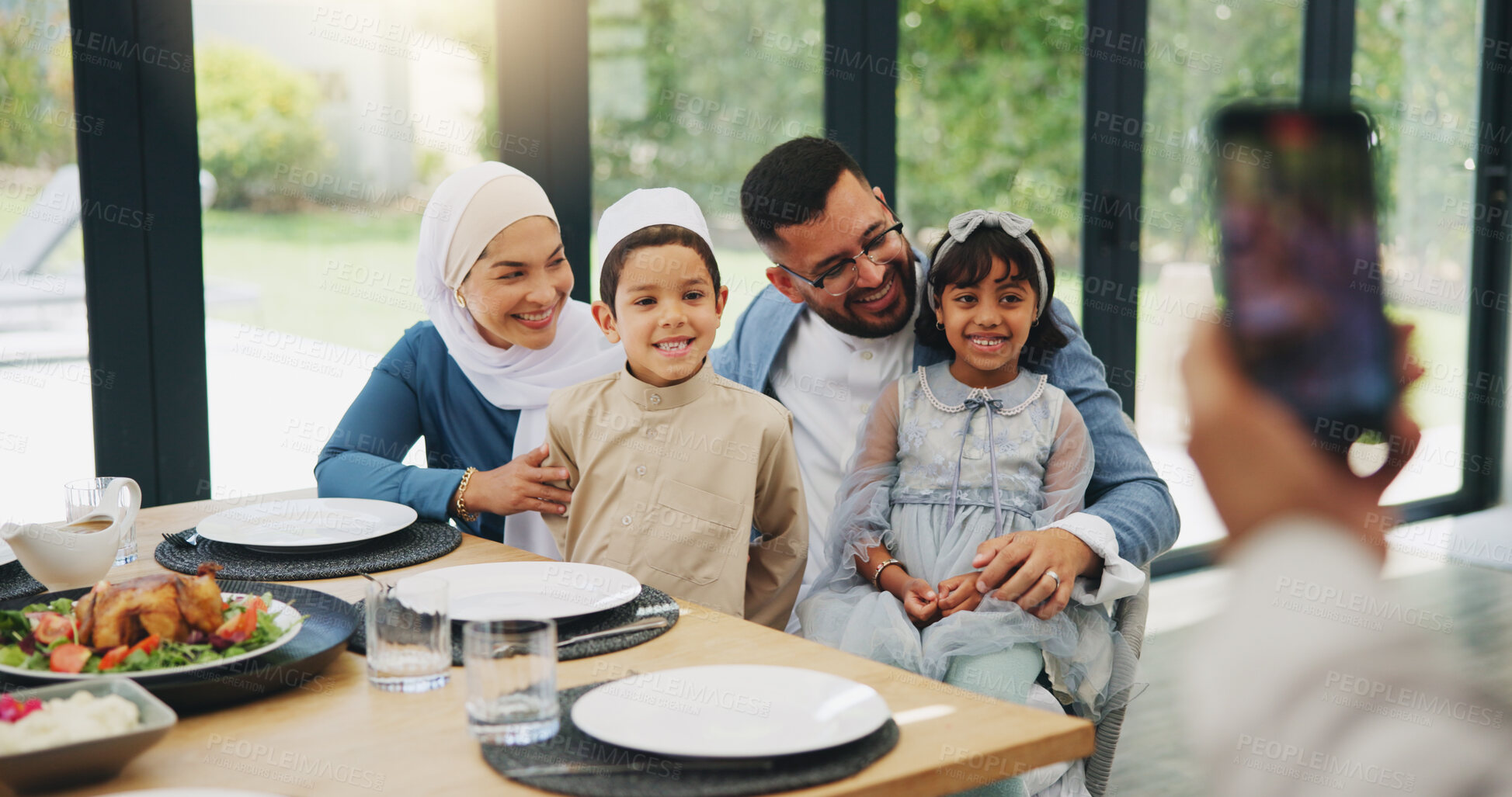 Buy stock photo Muslim, phone and photography with family lunch for eid mubarak in living room of house and celebration. Islam, mobile and memory with dinner in lounge of home for culture or festival after ramadan