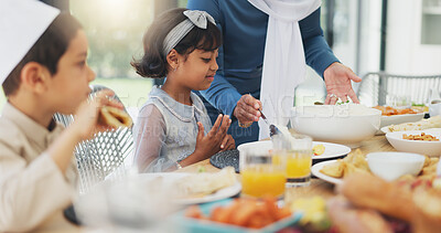 Buy stock photo Muslim, children and eating food with family for eid mubarak in living room of house for celebration. Islamic, kids and festival with dinner in lounge of home for culture or tradition after ramadan