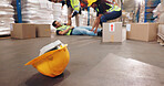 Accident, fall and helmet with man in warehouse for delivery, distribution or supply chain logistics. Fail, hardhat or injury and person on floor of plant with box for ecommerce, retail or safety