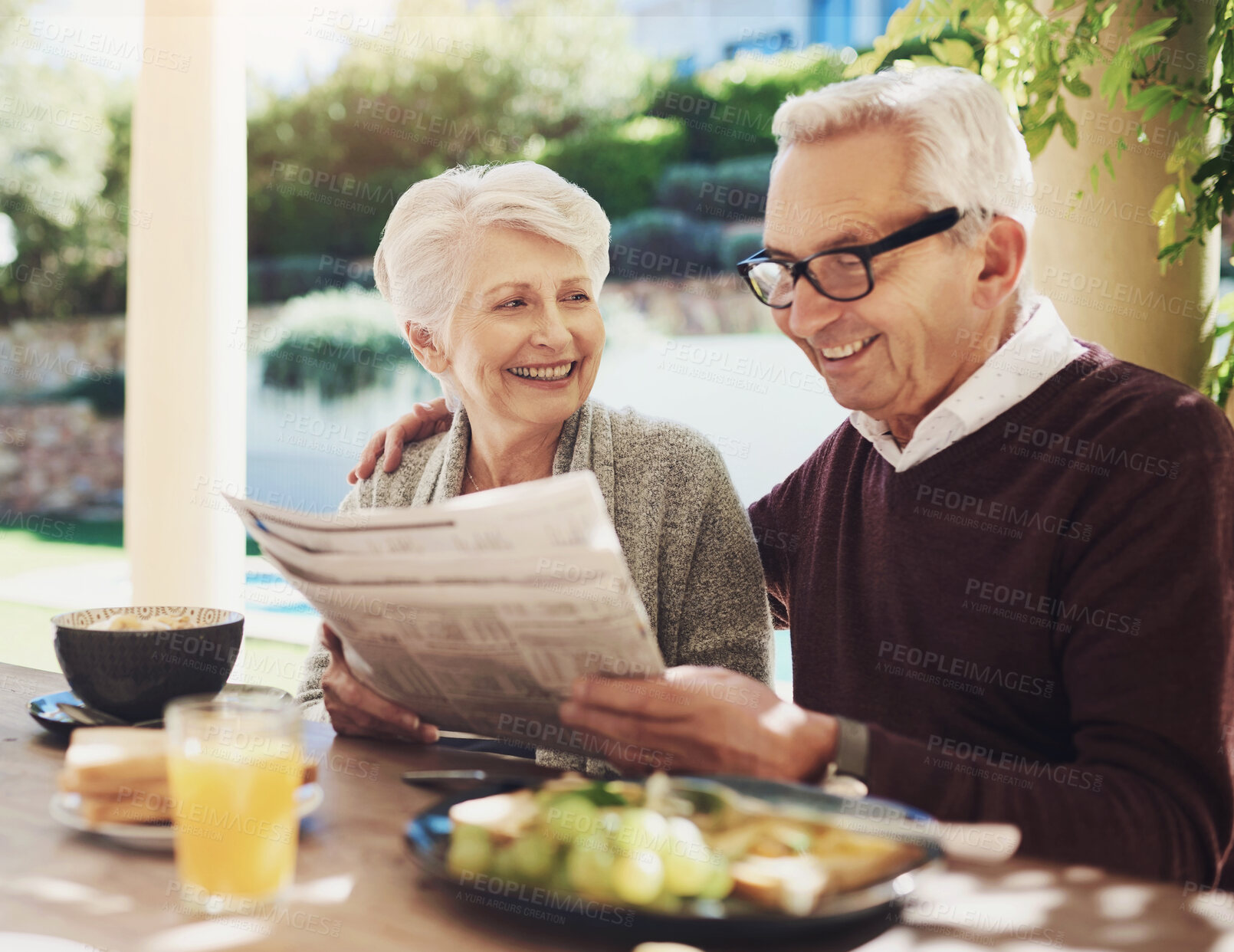 Buy stock photo Senior couple, newspaper and breakfast together in home, garden and bonding with food and coffee. Nature, happy or married people in house for brunch in retirement, meal and support with love