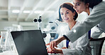 Women, laptop and microscope in lab with discussion, point and check results for pharmaceutical research. People, scientist and partner with review, feedback and reading by computer in collaboration