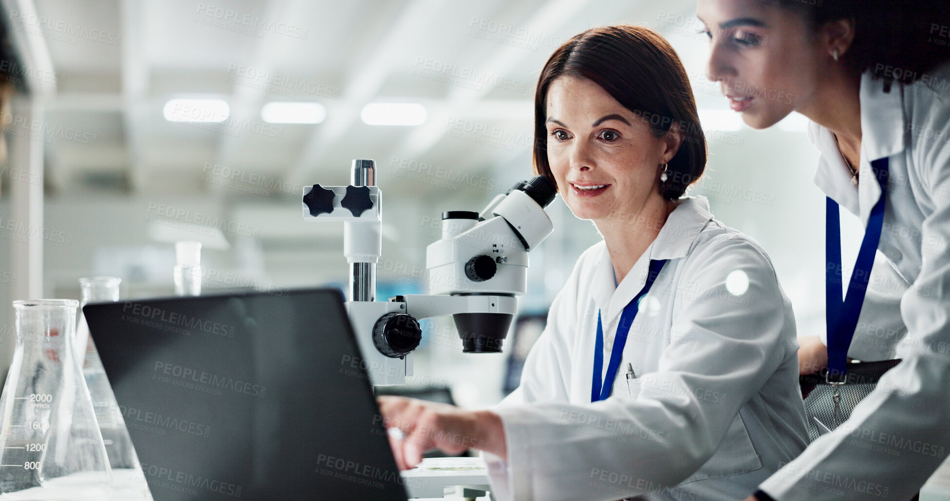 Buy stock photo Happy woman, scientist and coaching intern with laptop for research, discovery or breakthrough at lab. Female person training junior biologist on computer in medical study, exam or test at laboratory