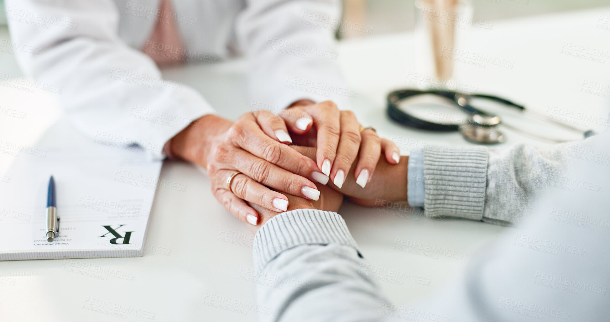 Buy stock photo Doctor, patient and holding hands on desk in consultation room with support, empathy and announcement. Medic, person and care with comfort, diagnosis and helping with healthcare service at hospital