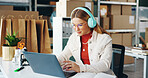 Woman, laptop and product with headphones, reading and logistics for thinking, sales report and ecommerce. Entrepreneur, computer and planning schedule for delivery, analytics or supply chain on web