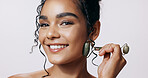 Face roller, smile and woman with cosmetics, glow and makeup on grey studio background. Portrait, happy person and model with tool, wellness and beauty with skincare, dermatology and grooming routine