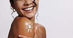 Lotion, sun and shoulder of woman in studio with moisturizing, health and skincare routine. Smile, dermatology and female person with spf cream for smooth body texture by white background with mockup