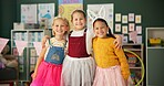 Happy girls, friends and hug with costume in class for dress up or casual day at school together. Portrait of children or kids with smile for halloween in princess outfit, tutu or fairy tale in room