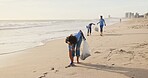 Volunteer, beach or people with plastic bag in nature for sustainability, help or ocean cleaning project. Accountability, team or volunteer at sea for earth day, social responsibility or NGO charity