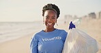 Beach, face or happy black woman with plastic bag for earth day, sustainability or ocean cleaning project. Recycle, sustainability and portrait of volunteer at sea for NGO, accountability or charity