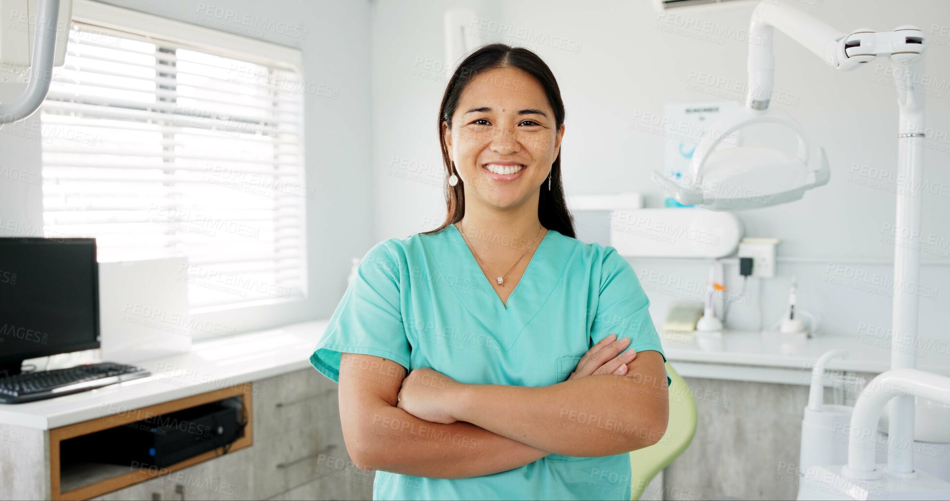 Buy stock photo Face, dentist and arms crossed with asian woman in scrubs at hospital for dental care or oral hygiene. Portrait, smile for medical and happy young orthodontist professional at clinic for dentistry