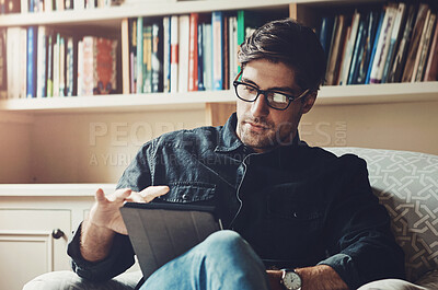 Buy stock photo Reading, relax and tablet with man on sofa in living room of home for break, comfort or weekend time off. Ebook, glasses and technology with person chilling in apartment for peace, leisure or rest