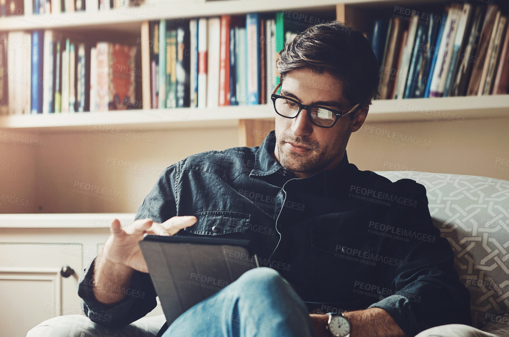 Buy stock photo Reading, relax and tablet with man on sofa in living room of home for break, comfort or weekend time off. Ebook, glasses and technology with person chilling in apartment for peace, leisure or rest