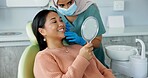 Dentist, teeth and woman with mirror for dental care, medical appointment or consultation at clinic. Healthcare, asian female patient and orthodontist for oral hygiene, wellness and cleaning.