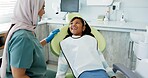 Dentist, woman and kid consulting for dental, health and teeth cleaning service with medical advice or support. Orthodontist or doctor talking to kid or girl of tooth with happy or funny conversation