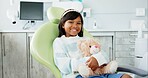 Face, dentist chair and girl with teddy bear, kid and smile with wellness and oral hygiene. Portrait, person and child with a toy and stuffed animal with checkup and appointment with dental care