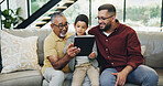 Tablet, sofa and child with father and grandfather choose movie, video or film together. Happy, bonding and boy kid watching film on digital technology with dad and senior man in living room at home.