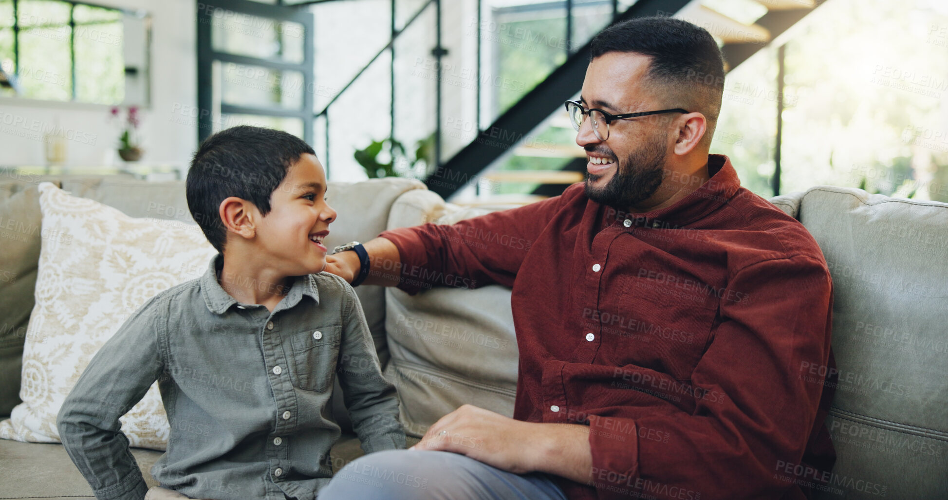 Buy stock photo Smile, bonding and child with dad on sofa relaxing together for fathers day celebration at home. Happy, love and boy kid talking to man for care and family time on couch in living room at house.