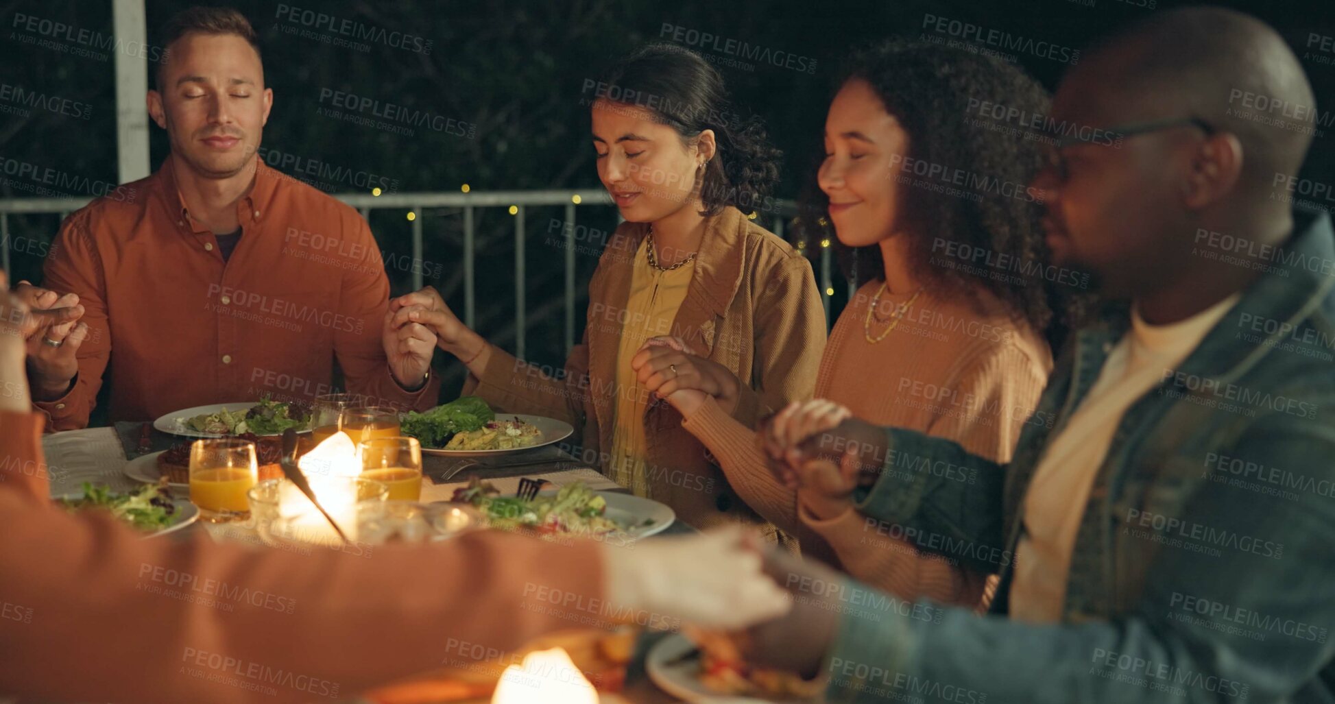 Buy stock photo Friends, holding hands and pray, food and worship together, gratitude and thanks to God at dinner party. Men, women and diversity with nutrition and religion, celebration and social event at night