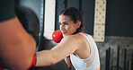 Fitness, woman and boxing in gym for training, self defence and exercise with personal trainer. Power workout, punch and female athlete with equipment for sport, learning and fighting with hard work