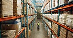 Warehouse, shipping and person walking in a distribution, freight and supply chain company. Worker, contractor and back with stock, factory and export business with employee working with storage