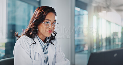 Buy stock photo Woman, doctor and office with reading on laptop for research or study results and feedback. Healthcare, medical and serious with telehealth for medicine, patient information and report at clinic