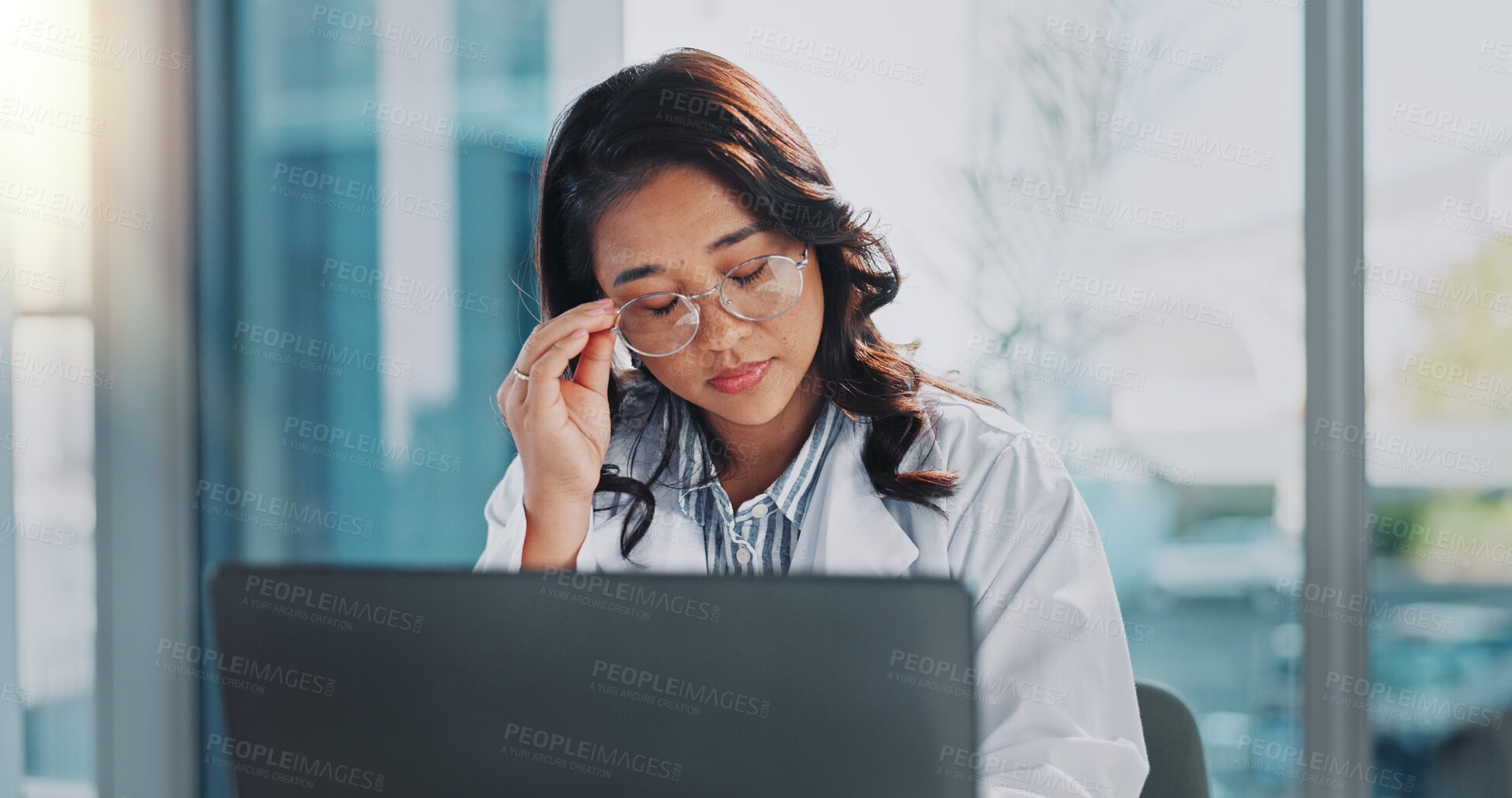 Buy stock photo Stress, doctor and Asian woman on laptop in hospital for medical service, telehealth and research. Healthcare, clinic and person on computer with headache, frustrated and burnout for mistake or fail