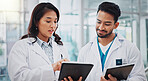Doctors, man and woman with tablet, discussion or check results for medical services at hospital. People, happy and digital touchscreen in clinical study, review and feedback at clinic in Indonesia