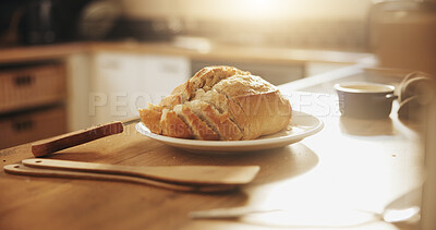 Buy stock photo Kitchen, breakfast and bread on counter in morning with slice for sandwich, diet and meal. Food, baking and baked goods, roll or loaf on wooden table for wellness, health and carbohydrates in home